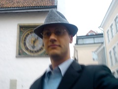 In front of a cool old clock onthe curch at the square in the midle of old town