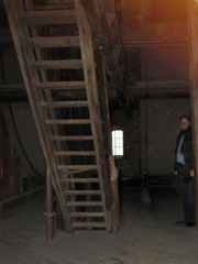 I am standing in front of a cage wheel. and stairs to the upper level